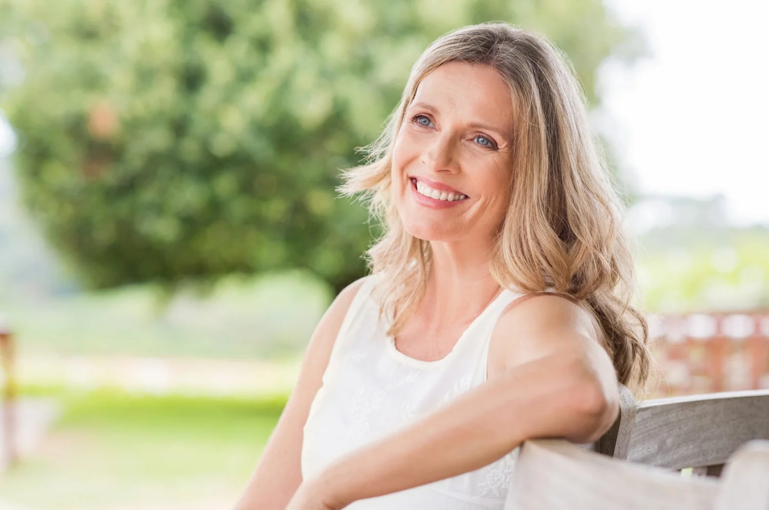 Une femme souriante, dans la douceur d’un jardin